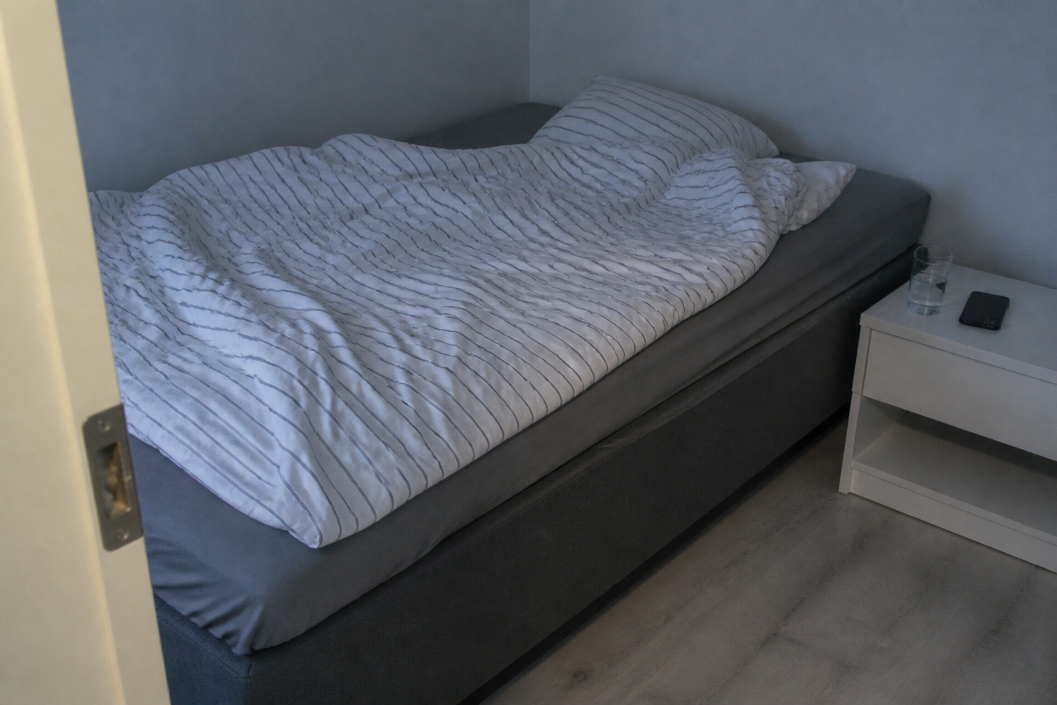 A calm evening routine with a phone set aside and water by the bed