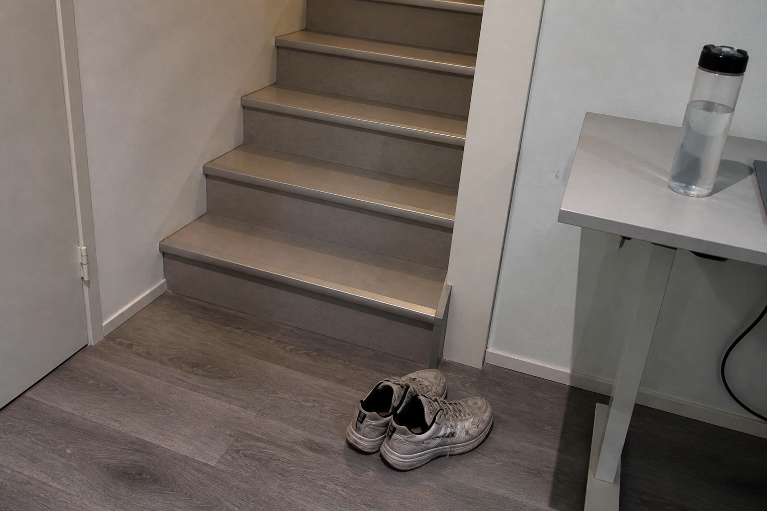 A standing desk, stairs and walking shoes in an ordinary home