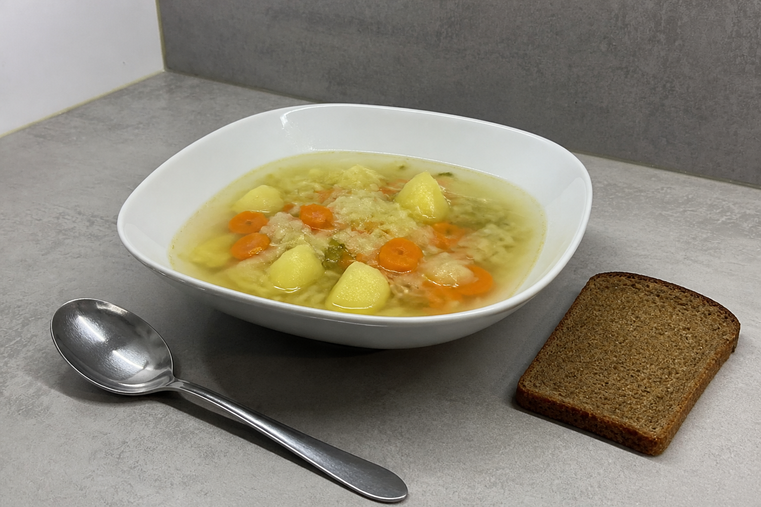 A vegetable-rich soup and salad beside a small snack