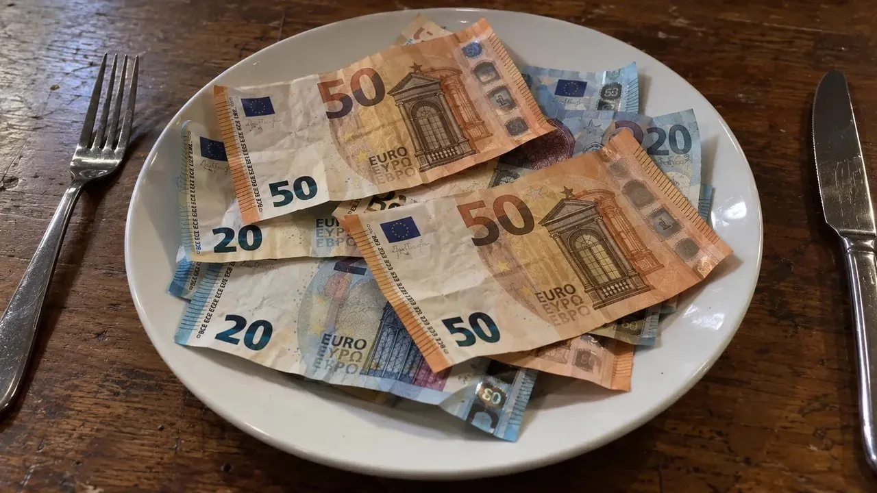 Raha ja painonpudotus: euroseteleitä valkoisella lautasella haarukan ja veitsen välissä puupöydällä